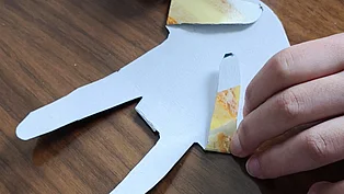 Ein Kind faltet aus Papier einen Hasen. 