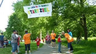 Der Spendenlauf der Laurentius Schule Köln ©OroVerde Viele Läufer*innen laufen vor dem Schild "Ziel" ein.