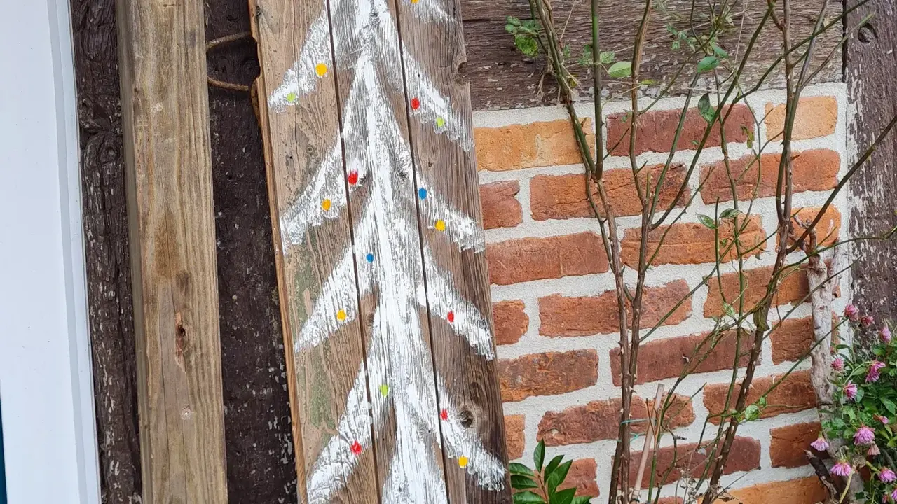 Weihnachtsbaum aufgemalt auf einem Holzscheit