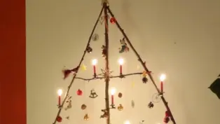Ein aus verschieden großen Zweigen gebauter Weihnachtsbaum. Er ist geschmückt.