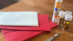 Bastelmaterialien für einen Papierstern: Brottüten, Schere, Kleber und Glitzer. 