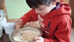 Ein Junge vermischt Zutaten für Salzteig in einer Schüssel.
