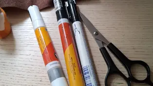 Stifte, brauner Filz und eine Schere auf einer Tischplatte.