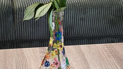 Eine selbst gestaltete Vase mit Blumen darauf.