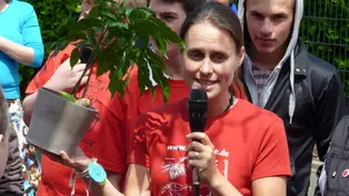 Ein symbolischer Baum als Gewinn ©OroVerde Eine Frau hält eine Rede, in der Hand hält Sie eine Pflanze, der als symbolischer Gewinn überrreicht wird.
