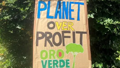 Fertiges Plakat mit festgeklebtem Stock auf der Rückseite. Der Spruch darauf lautet "Planet oder Profit"