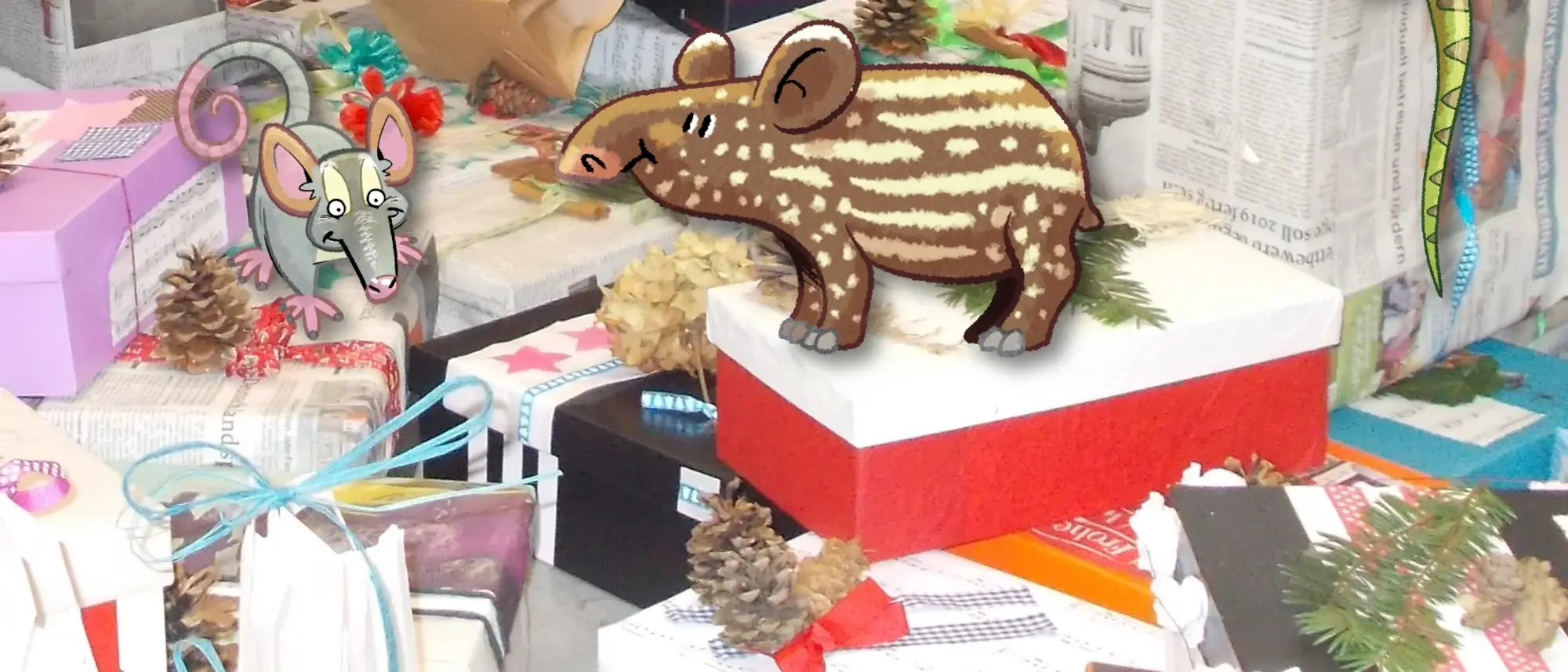 Ein Haufen Geschenke, alle auf nachhaltige Weise verpackt  - im Comic Stil hinzugefügt - ein Tapirjunges, ein Leguan und eine Graue Vieraugenbeutelratte.