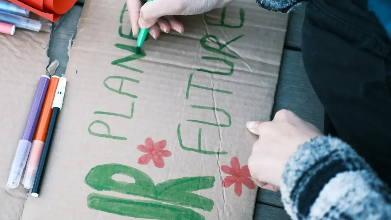 Ein Demoschild wird gebastelt auf dem "Our planet future" steht. 