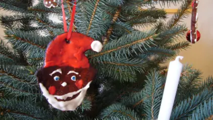 Gesicht des Weihnachztsmanns aus Lebkuchen gemacht als Anhänger am Weihnachtsbaum.