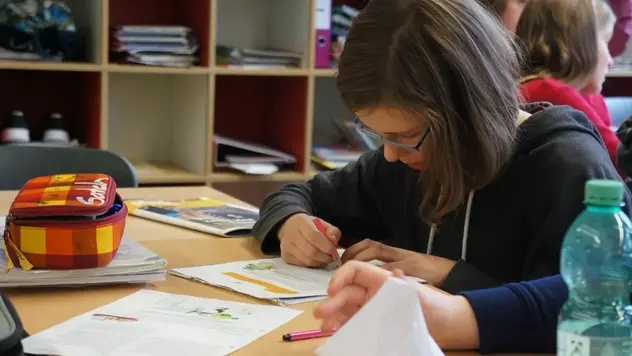 Antrag schreiben ©OroVerde/S. Korndörfer Ein Mädchen schreibt an einem Tisch sitzend einen Brief.