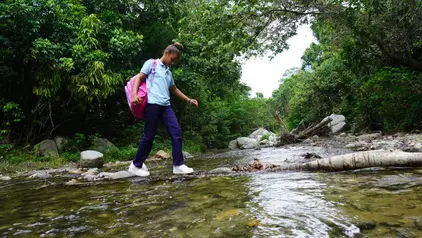 Melani´s Schulweg ©Centro Naturaleza/ S.Estevez Melanie, ein Mädchen aus der Dominikanischen Republik, auf ihrem Weg zur Schule, der sie durch einen Flusslauf führt.