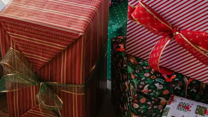 Geschenke ©Katie Azi/ unsplashplus Das Foto zeigt aufeinander gestapelte Geschenke mit Schleifen drumherum.