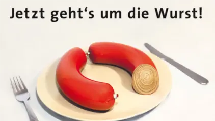 Plakat mit dem Slogan "Jetzt geht´s um die Wurst" zeigt eine Wurst auf einem Teller mit Bauringen statt Fleisch. 