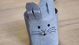 Ein Eierbecher in Form eines Hasen, gebastelt auf einer alten Toilettenpapierrolle. 