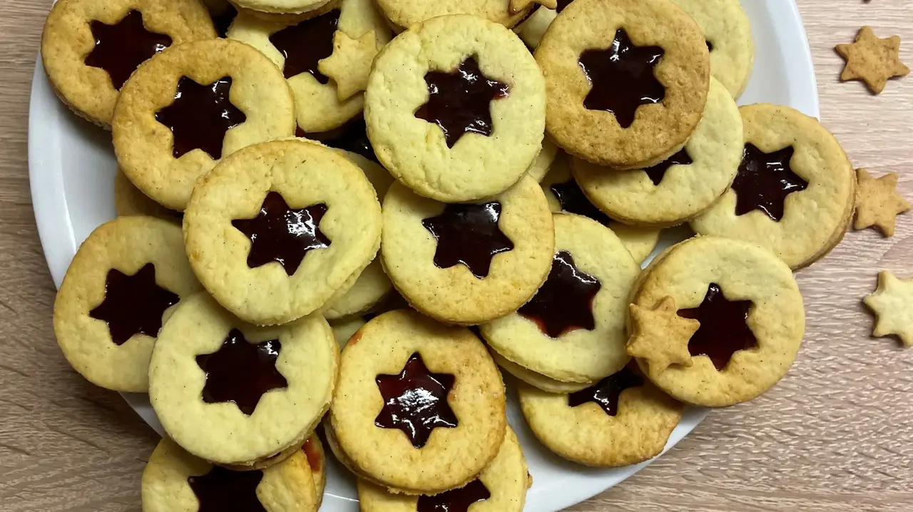 Kekse, die in der Mitte einen Stern aus Marmelade haben.